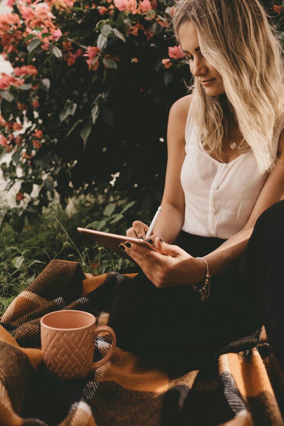 woman writing on iPad, quiet time, me time, heart centered, therapeutic, self care mindfulness